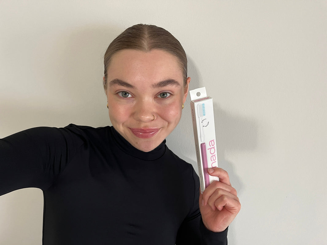 Woman holding a Pink Nada Toothbrush box