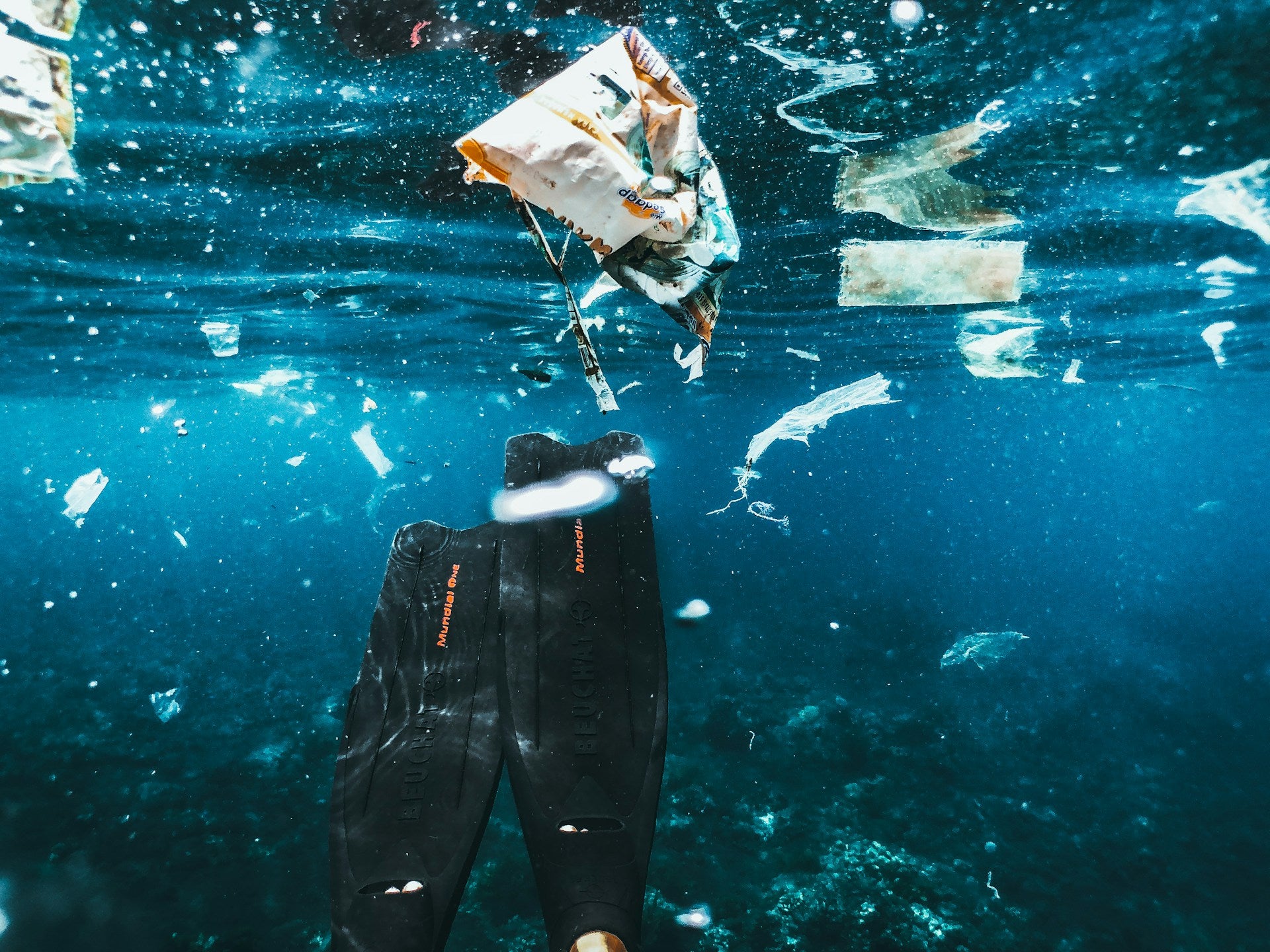 Scuba diver in water full of microplastics 