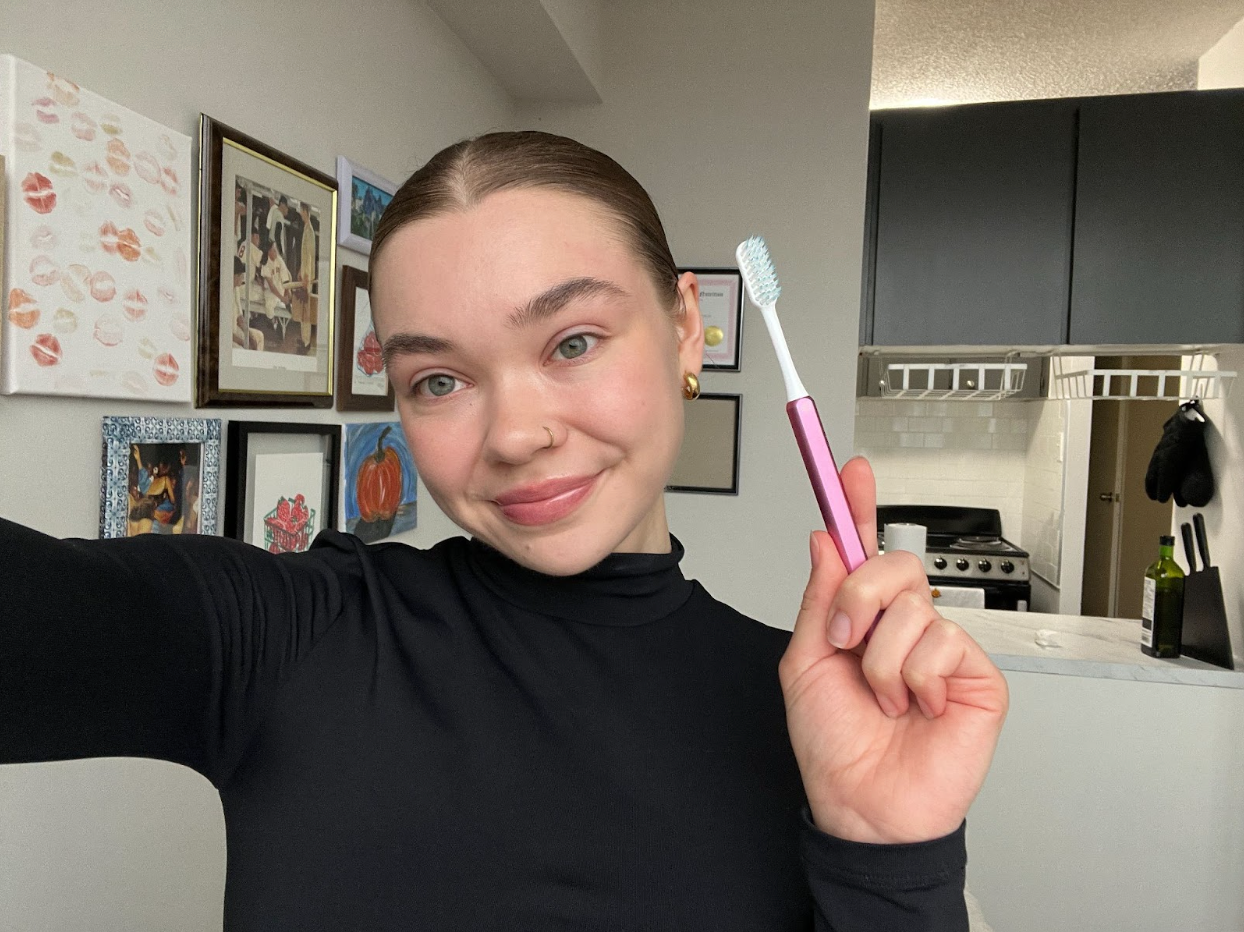 Young woman holding a pink Nada toothbrush