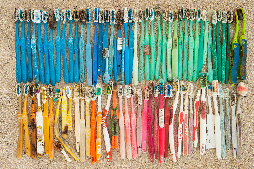 Old, plastic, disposable toothbrushes laying on a beach