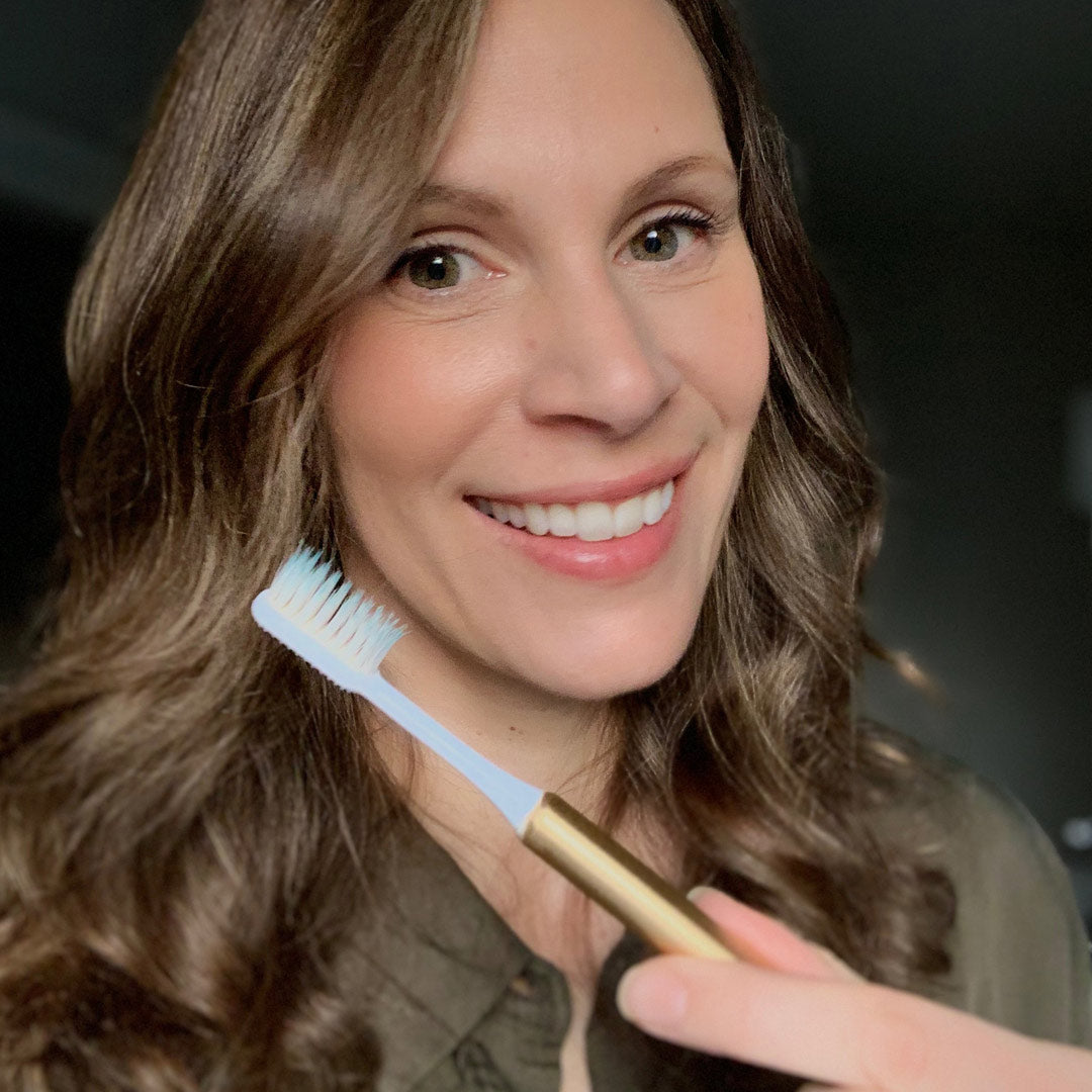 Nada customer with a gold Nada sustainable toothbrush