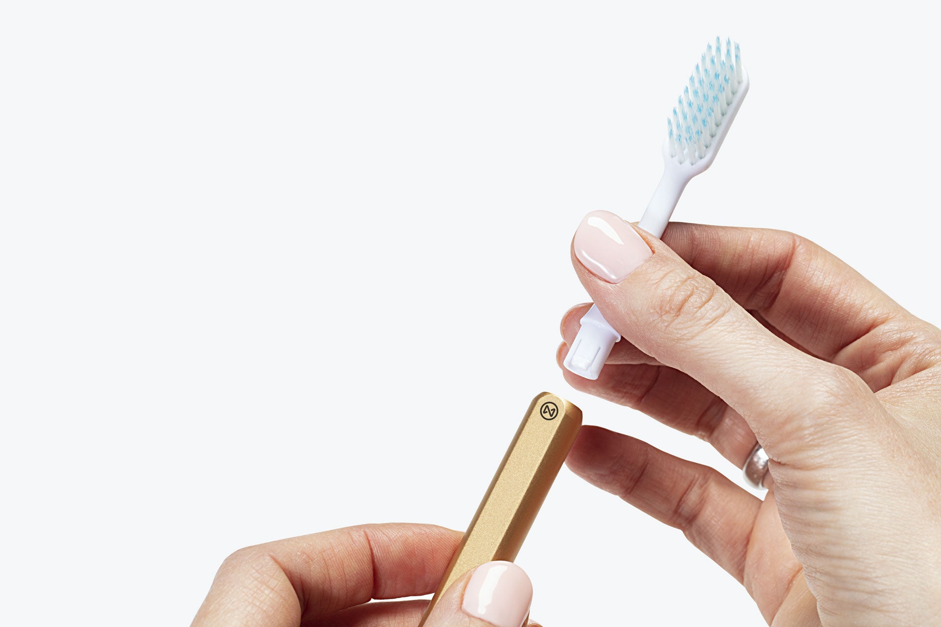Gold Nada eco-friendly toothbrush with hand removing the brush head