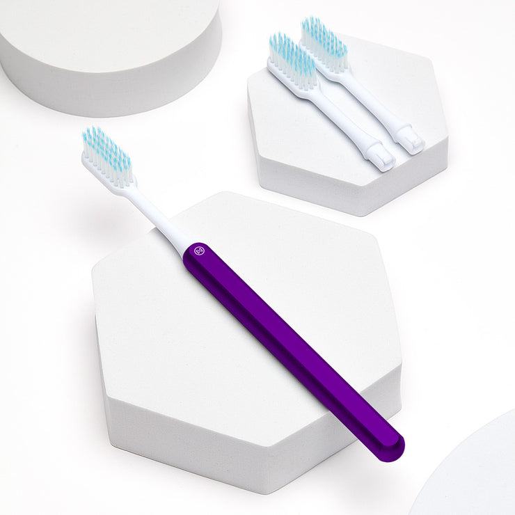 Purple Nada sustainable toothbrush with a metal handle and replacement brush heads