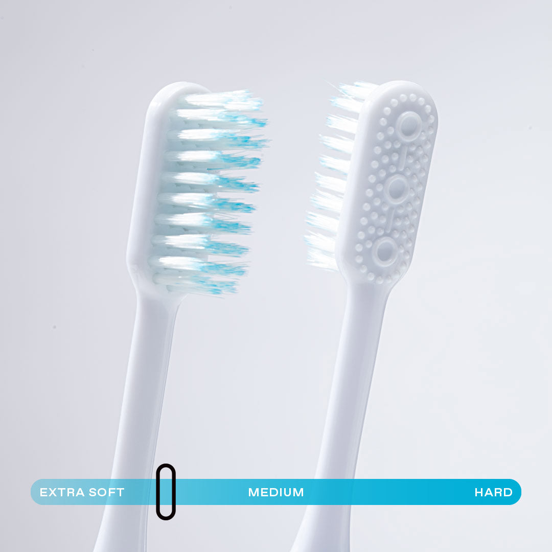 Close up of Nada eco-friendly manual toothbrush heads with built in tongue scraper and soft floss-tip bristles