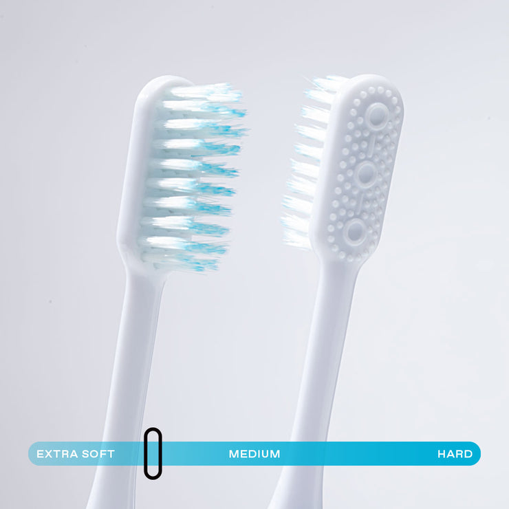 Close up of Nada eco-friendly manual toothbrush heads with built in tongue scraper and soft floss-tip bristles