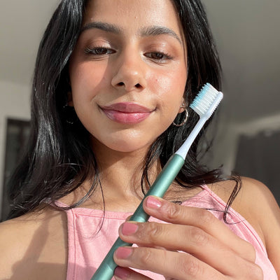 Mehak with a green nada toothbrush – with a metal handle and replacement brush heads that are recyclable