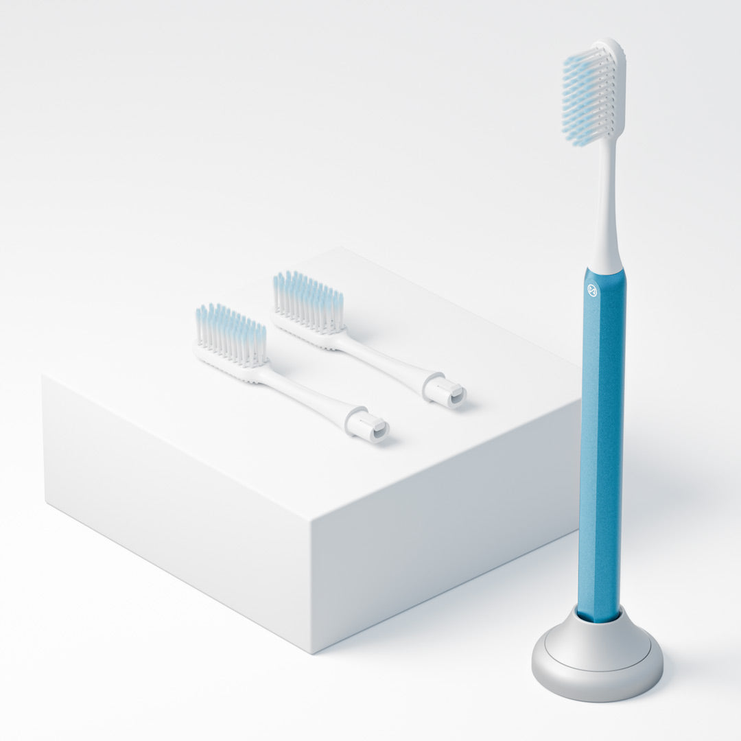 Kids blue Nada Toothbrush with an eco friendly aluminum handle and recyclable brush heads in a toothbrush stand