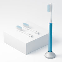 Kids blue Nada Toothbrush with an eco friendly aluminum handle and recyclable brush heads in a toothbrush stand