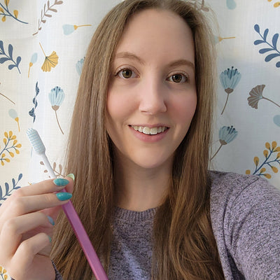 Sara with a pink, eco-friendly Nada toothbrush